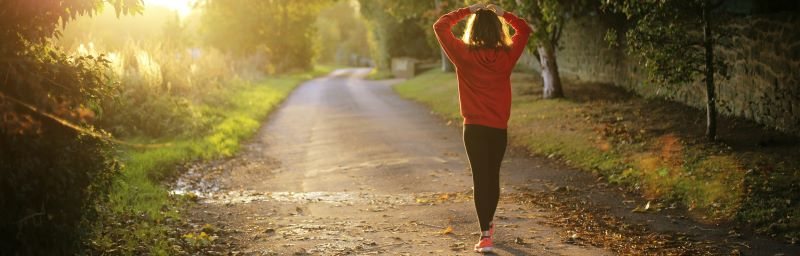 A person walking along a country path at sunrise