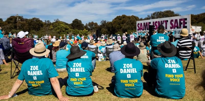 Supporters in teal t-shirts at a community rally