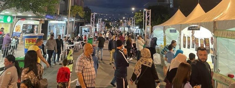 A busy Auburn street at night during Ramadan, with food stalls and crowds