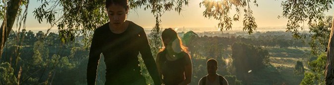 Two people outdoors among trees at sunset, overlooking Western Sydney