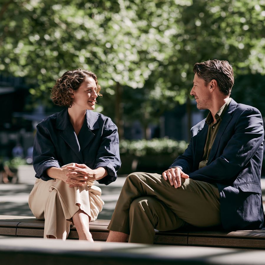 Two people talking on a bench