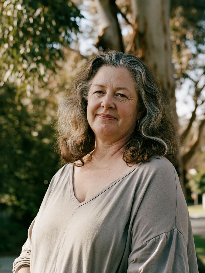 A woman standing outdoors under gum trees